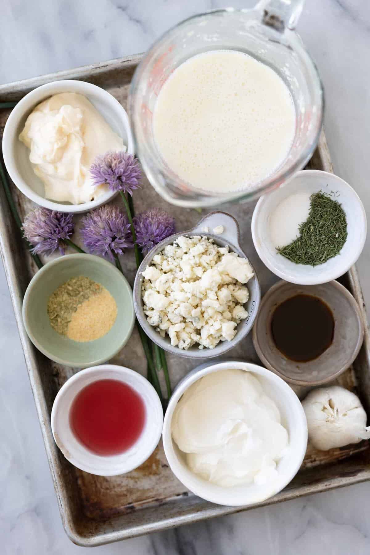 Ingredients to make this this wedge salad in bowls on a table.