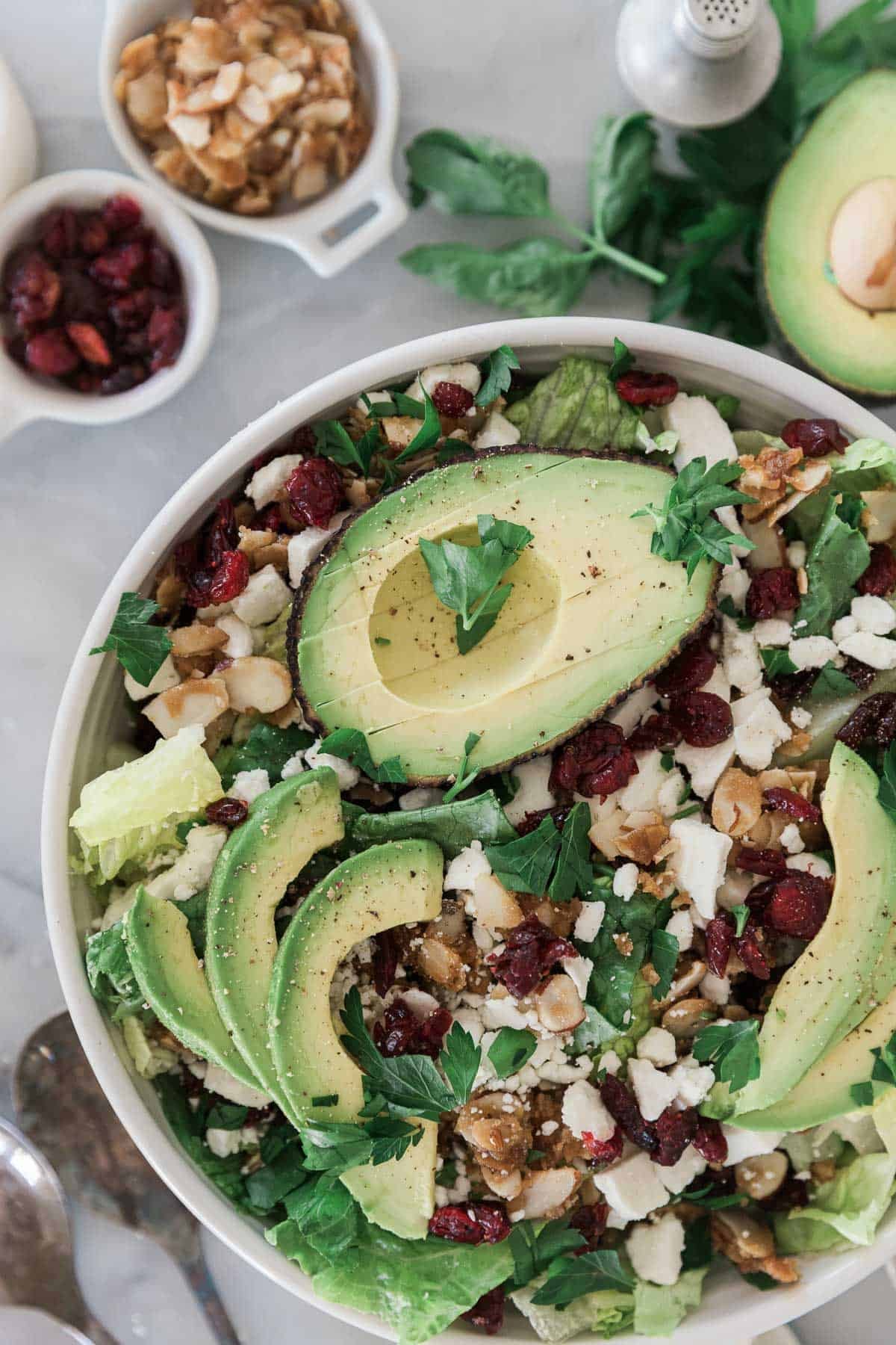 Avocado lettuce salad with almonds and feta on top.