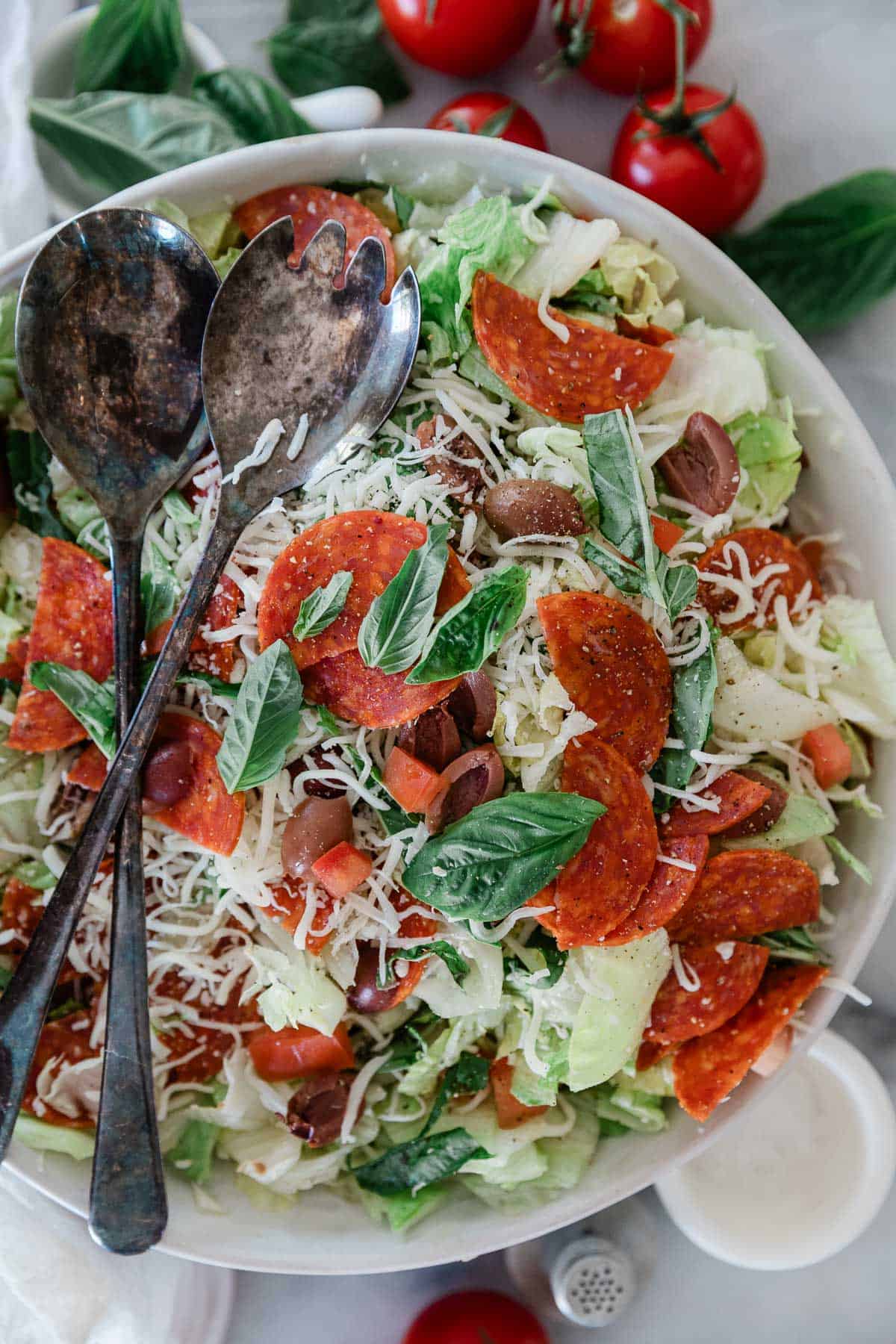 Pizza salad with a salad server on the side.