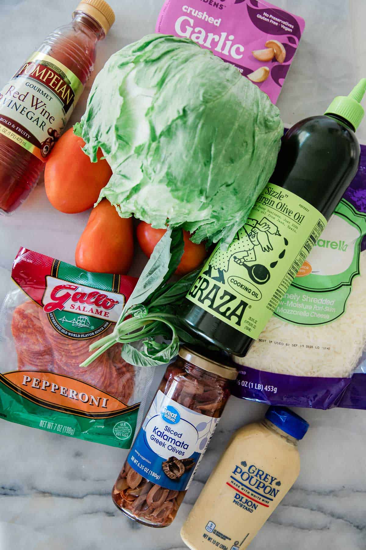 Ingredients to make this chopped pizza salad on a table.