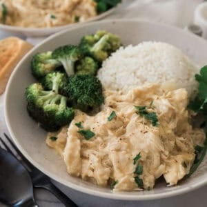 Crockpot smothered chicken with a side of rice and broccoli.