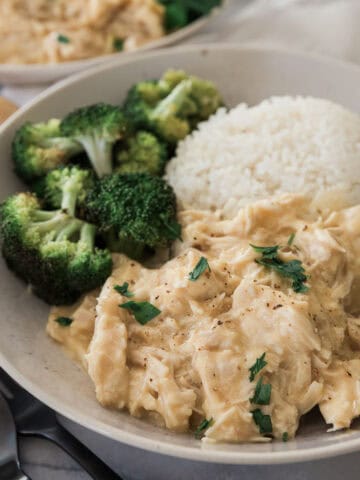 Crockpot smothered chicken with a side of rice and broccoli.